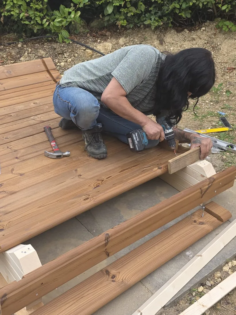 Diana aan het werk: het frame van een buitensauna wordt op maat vastgeschroefd.